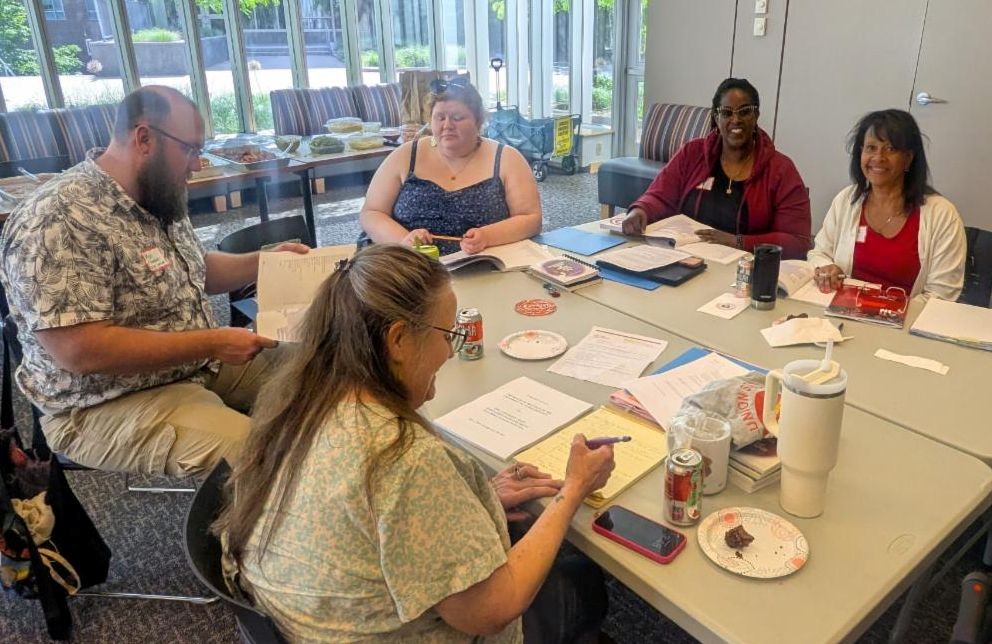 Group of union members gathered around table talking during Steward Training