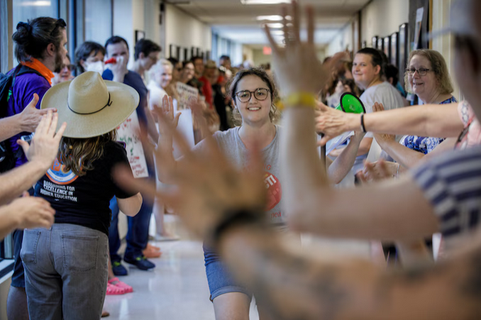 USA Chief Steward Camille Godbout-Chouinard high fives USA members and their allies line the hallway outside the UMass Chancellor's Office. Photo by Douglas Hook / The Republican.